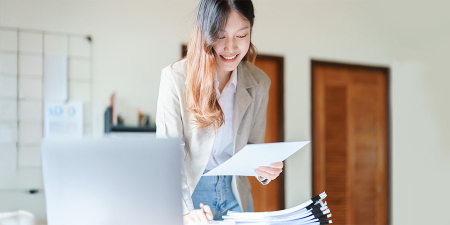 A music publisher standing at a desk looking at papers.