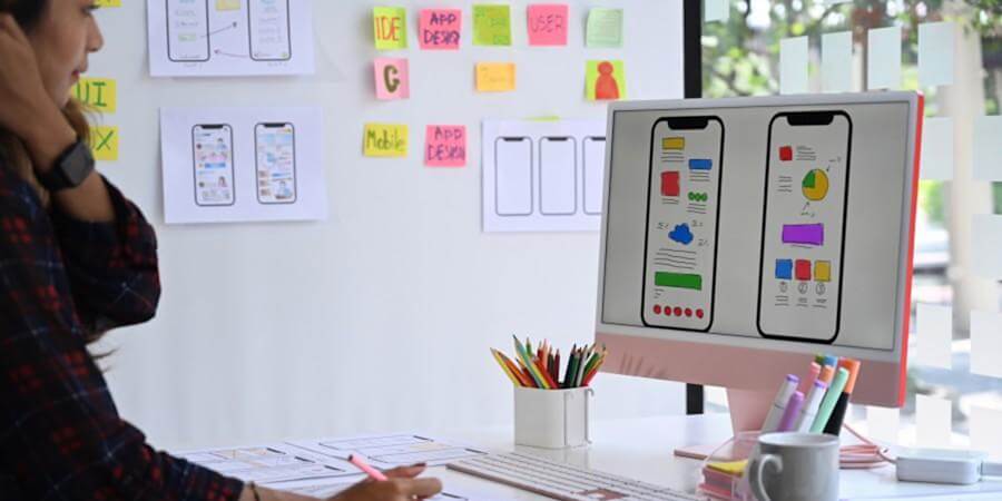 A UI designer in a studio works on a mobile app.