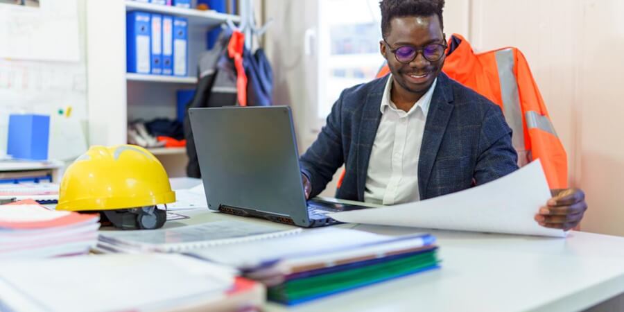 An industrial production manager reviews quality requirements in his office.
