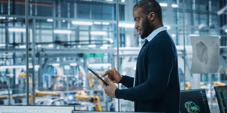 An analytics engineering reviewing data on a tablet in his office.