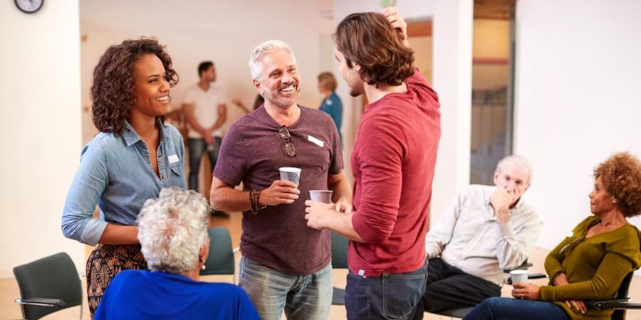 A community health worker speaks with community members at an information-sharing session.