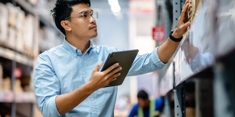 a supply chain manager holding a tablet taking inventory
